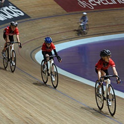 Cycling team on their bikes inside of a velodrome